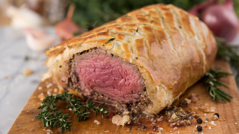 Half beef Wellington on cutting board