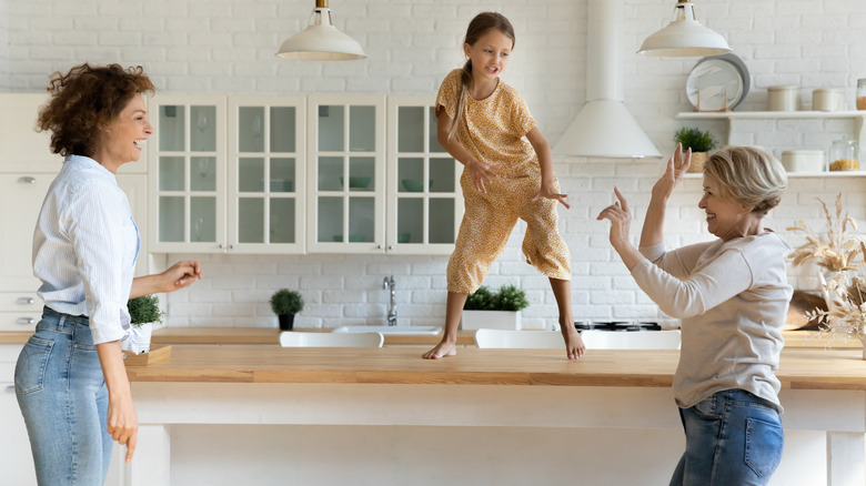 Three generations of women dancing in the kitchen