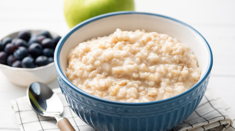 A blue bowl of oatmeal sitting on a table