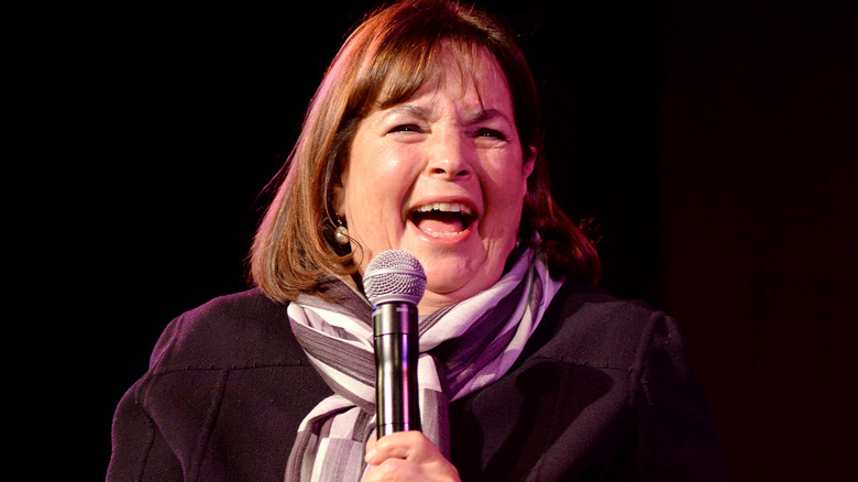 Ina Garten laughing on stage while holding microphone