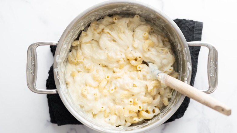 mixing macaroni and cheese in pot