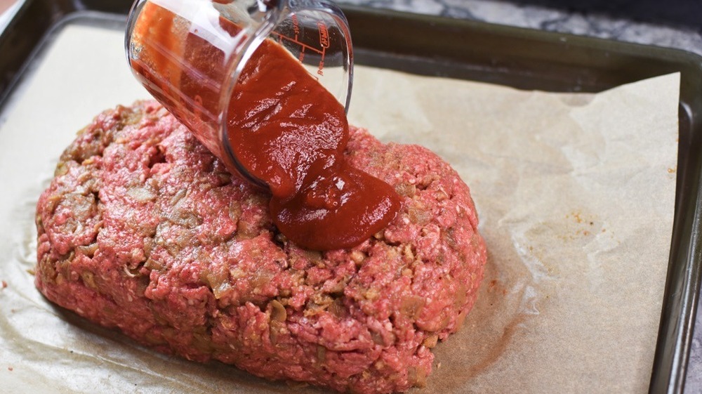 spreading ketchup over meatloaf