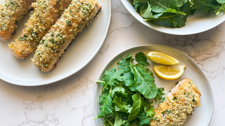 two plates with panko crusted salmon and salad