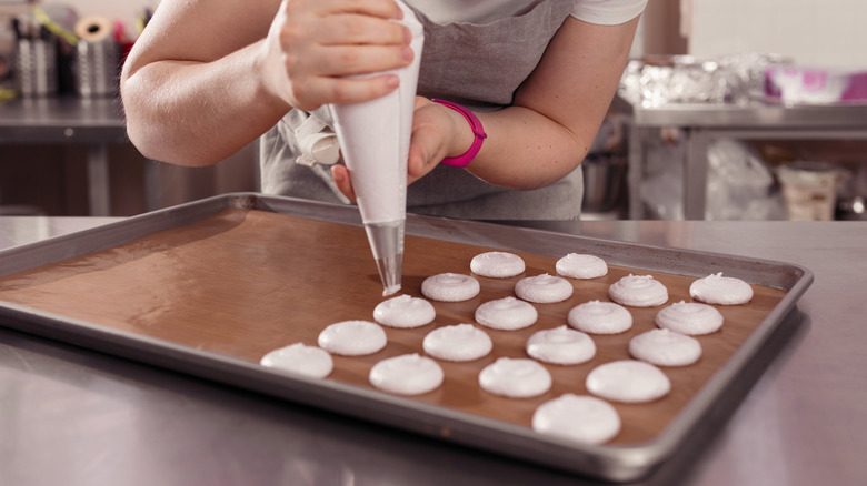 Chef piping white frosting circles