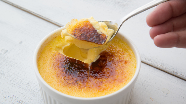 Person taking a spoonful of crème brûlée