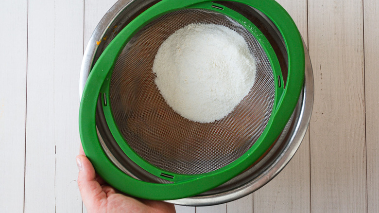 sifting flower through colander