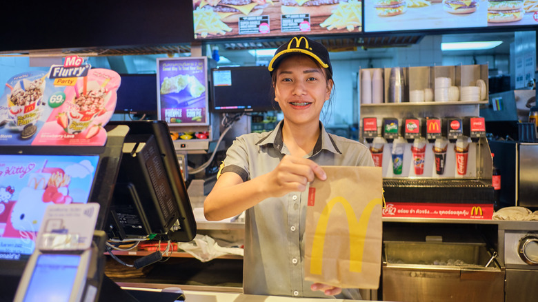 McDonald's worker holding out an order