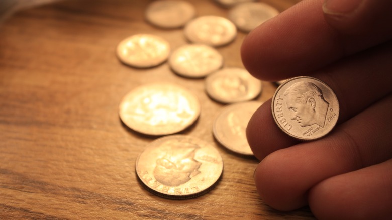 A man holding a dime