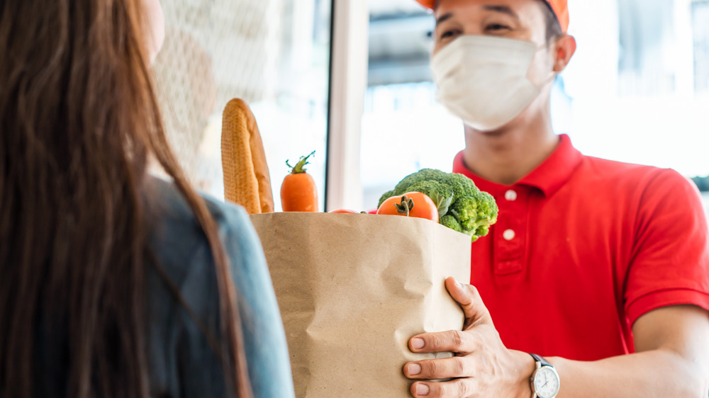 Man delivering groceries to woman