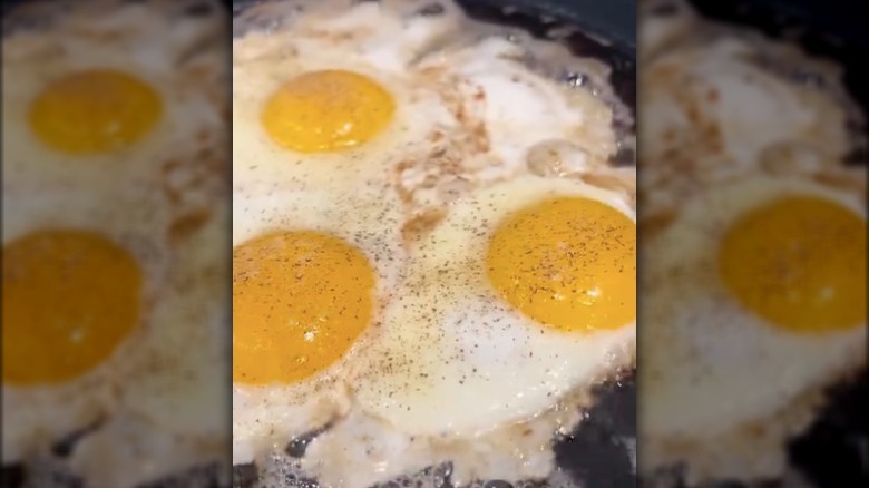 Three eggs frying in a pan