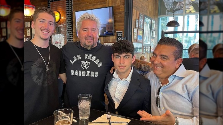 Hunter Fieri, Guy Fieri, Buddy Jr. Valastro and Buddy Valastro posing together at a restaurant