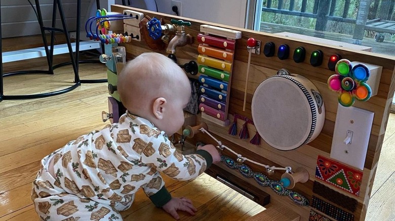 Goldman's daughter plays with a brown wooden board