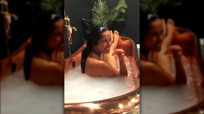 Padma Lakshmi smiling in her bathtub