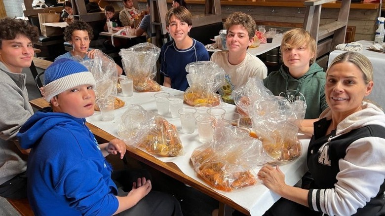 Cat Cora and family smiling at table with seafood feast