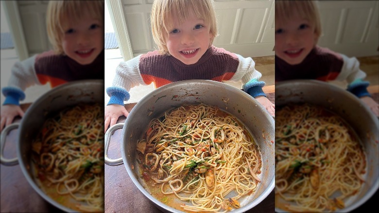 Jamie Oliver's son holding a bowl of pasta