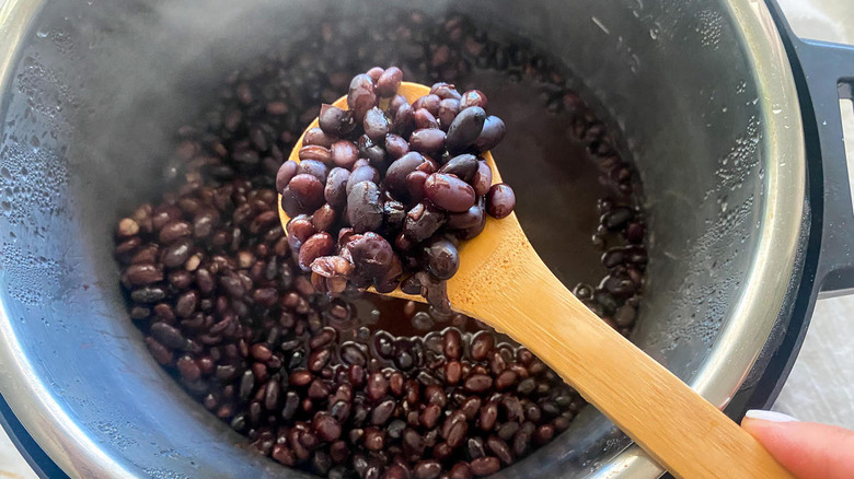 Spoonful of beans over steaming instant pot