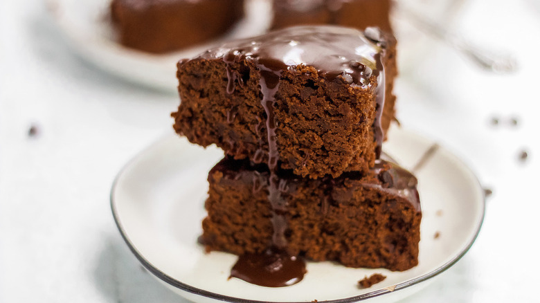 Two brownie slices stacked with fudge on top