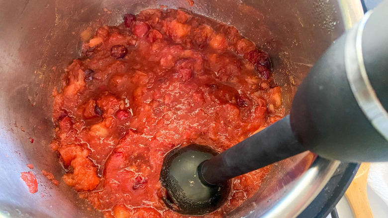 mashing applesauce with immersion blender