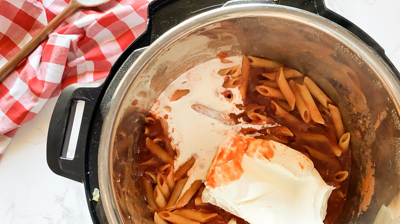 mixing cream cheese into penne