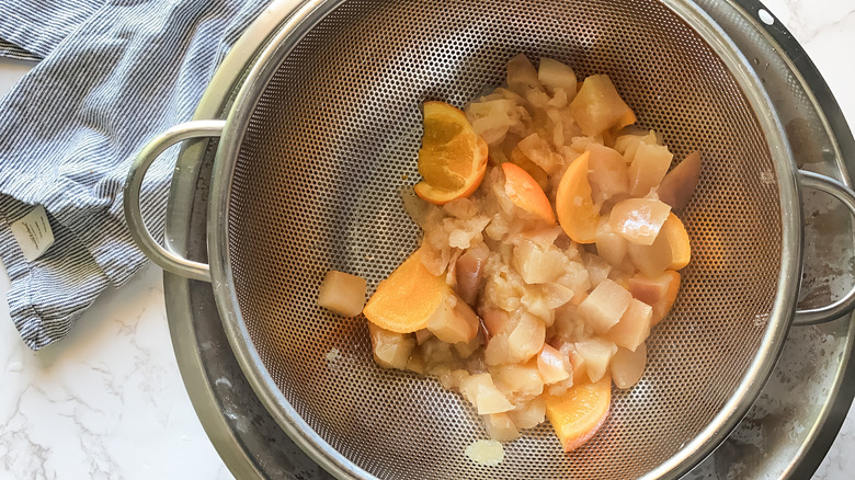 apples and oranges in strainer 