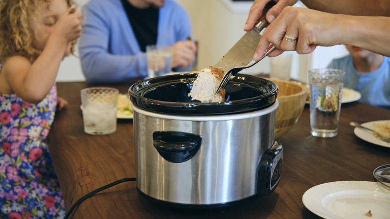 slow cooker on table with family