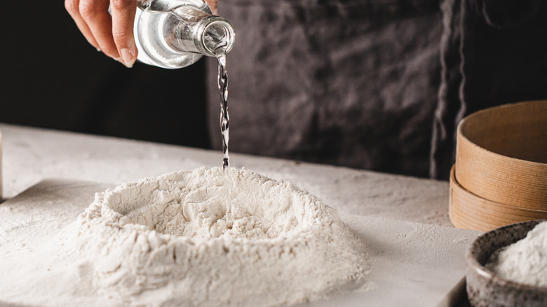 mixing water into dry ingredients for bread dough