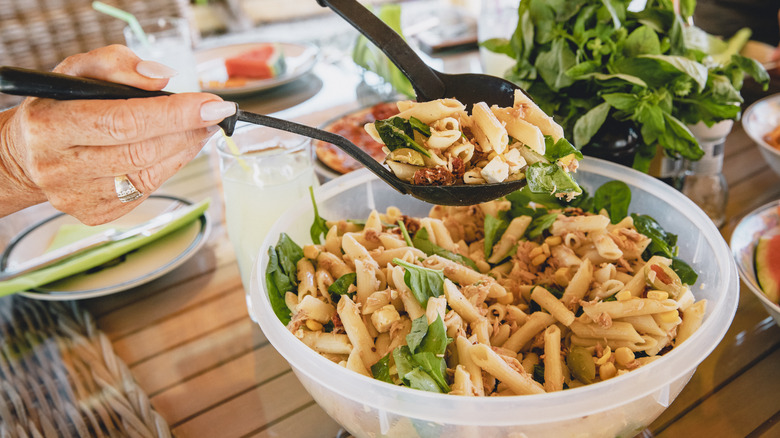 Person serving pasta salad