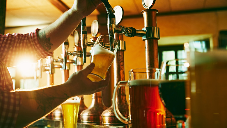 Bartender pulling beer from tap in a pub