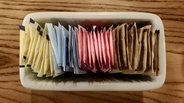 Sweetener packets lined up in container