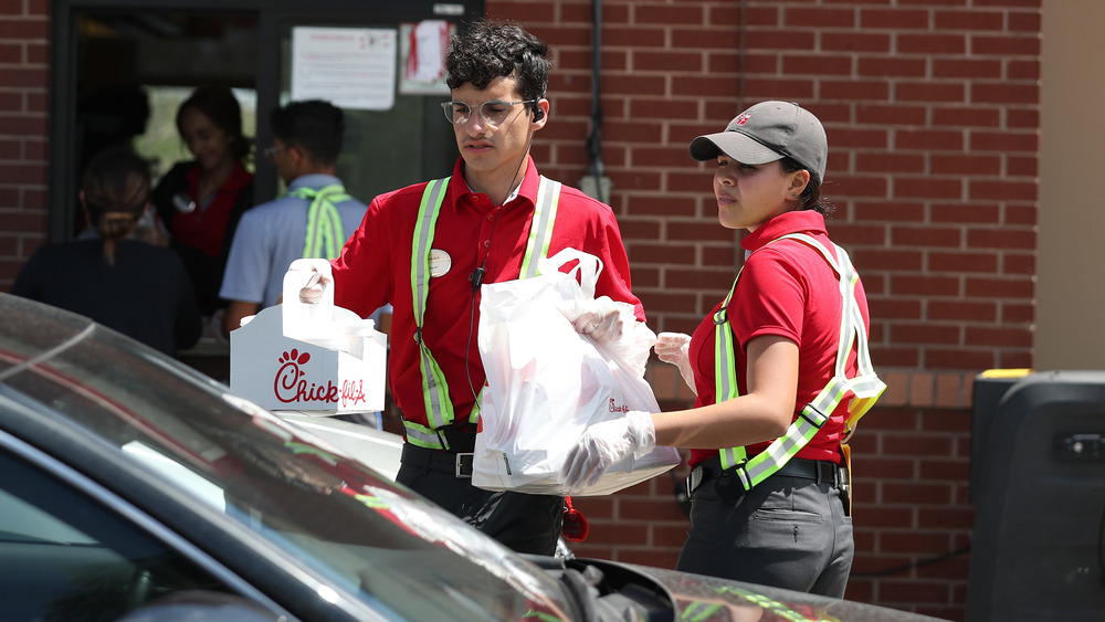 Chick-fil-A employees holding food at drive thru