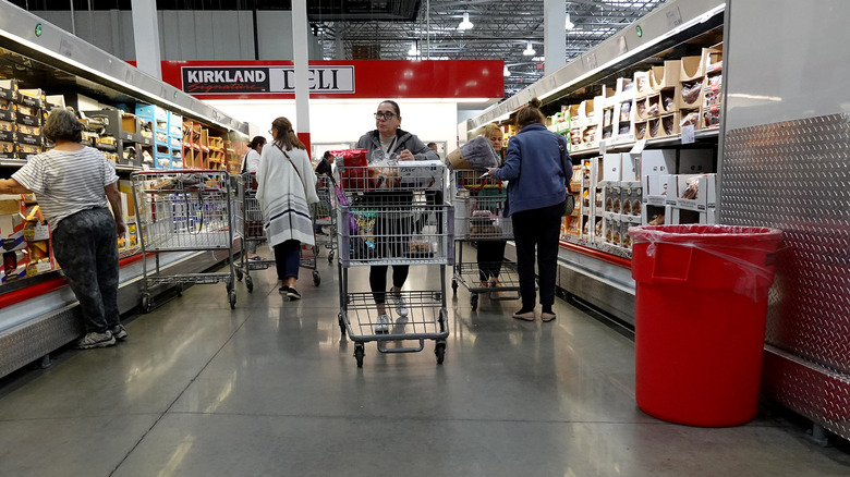 shoppers pushing carts Costco aisle