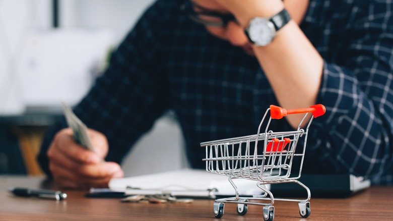 Man holding his head in frustration over food prices