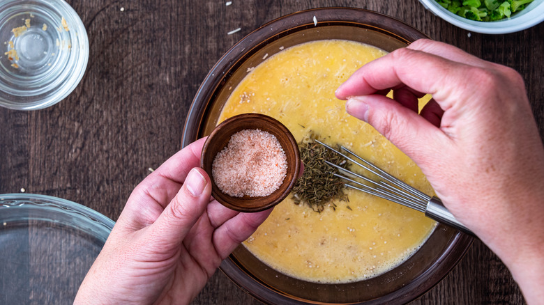 hands seasoning food with Himalayan pink salt