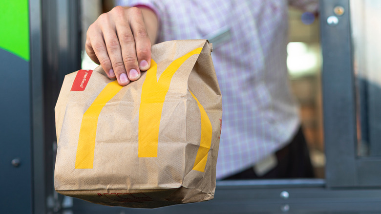 McDonald's employee handing over order in drive-thru