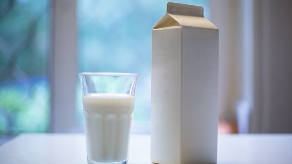 milk in glass next to carton