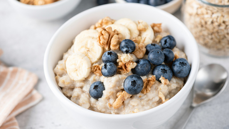 bowl of oatmeal topped with bananas, blueberries, and granola