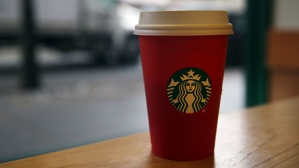 A Starbucks Red takeaway coffee cup on a table