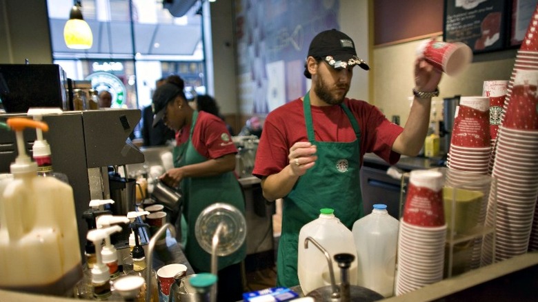 two Starbucks employees making drinks