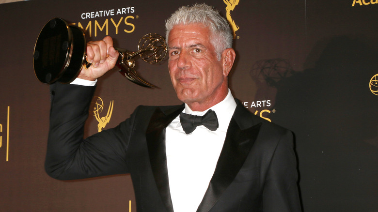 Anthony Bourdain holding an Emmy