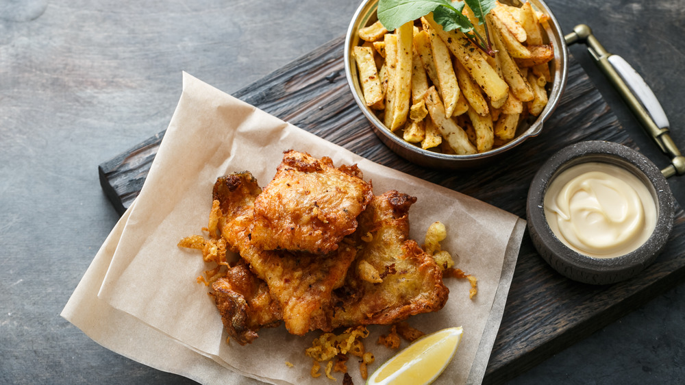 Fish and chips on a wooden tray with a side of mayonnaise