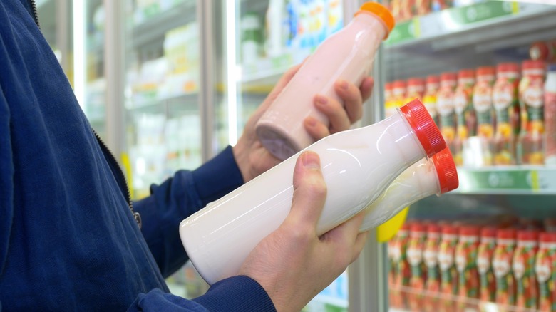 Person holding milk bottles