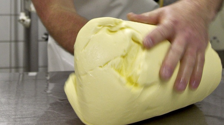 Hands rolling log of butter