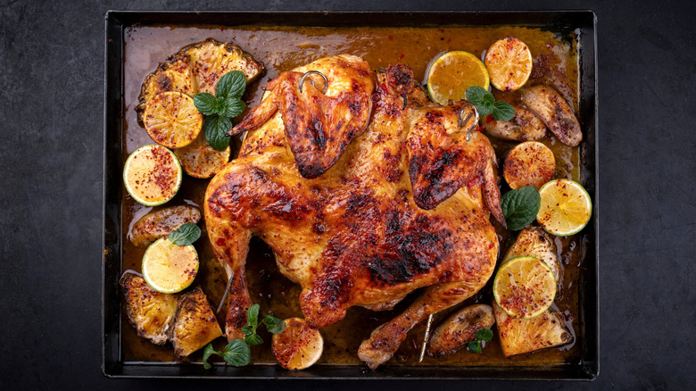 Spatchcocked chicken on baking tray with fruit