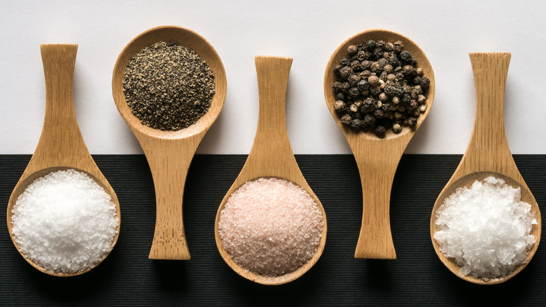 small bowls of different types of salt and pepper