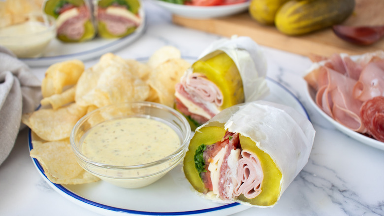 pickle sandwich with creamy yellowish sauce and potato chips