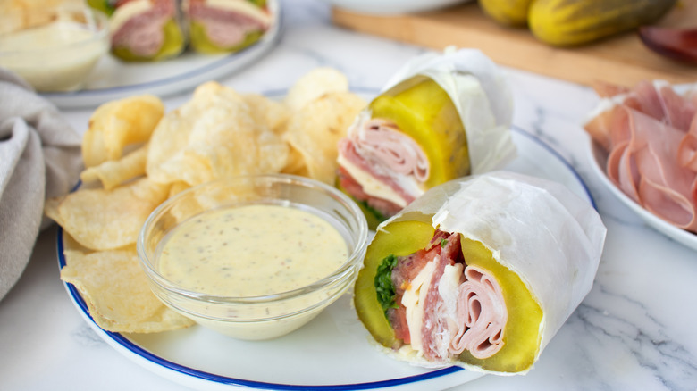 pickle sandwich with creamy yellowish sauce and potato chips