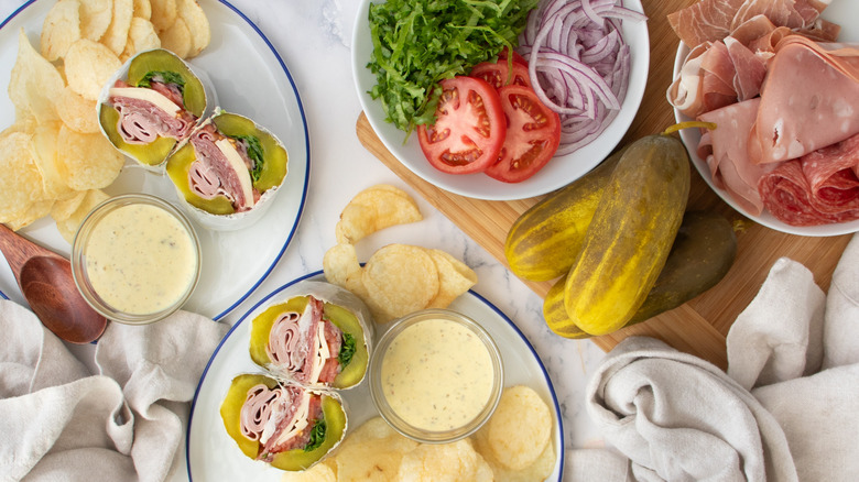 sandwiches with pickles, vegetables, and potato chips