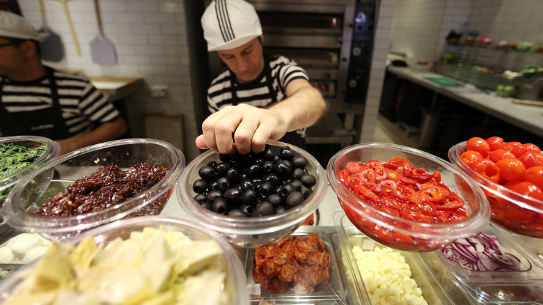 pizza chef grabbing toppings