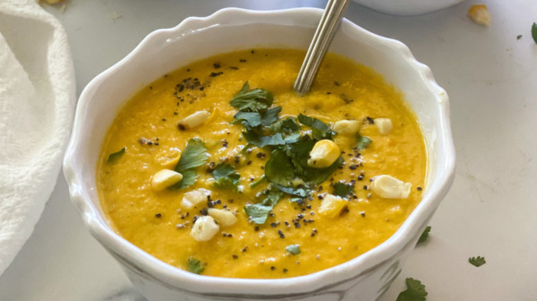 Bowl of thick corn soup with chopped cilantro. 