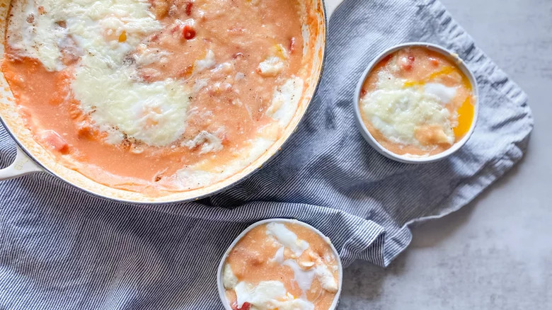 Bowls of tomato polenta with baked egg on top. 